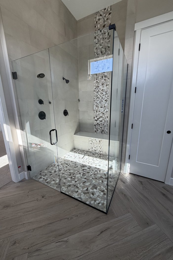 Frameless shower enclosure with matte black hardware by Kent Glass in Colorado Springs