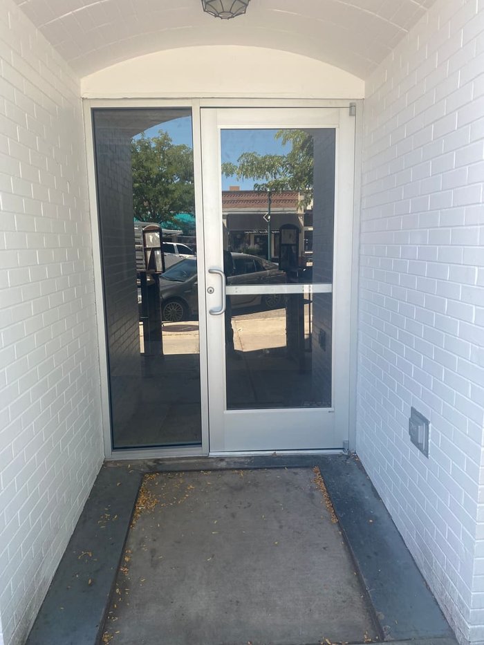 Aluminum commercial entry door with glass sidelite in a tiled storefront vestibule by Kent Glass