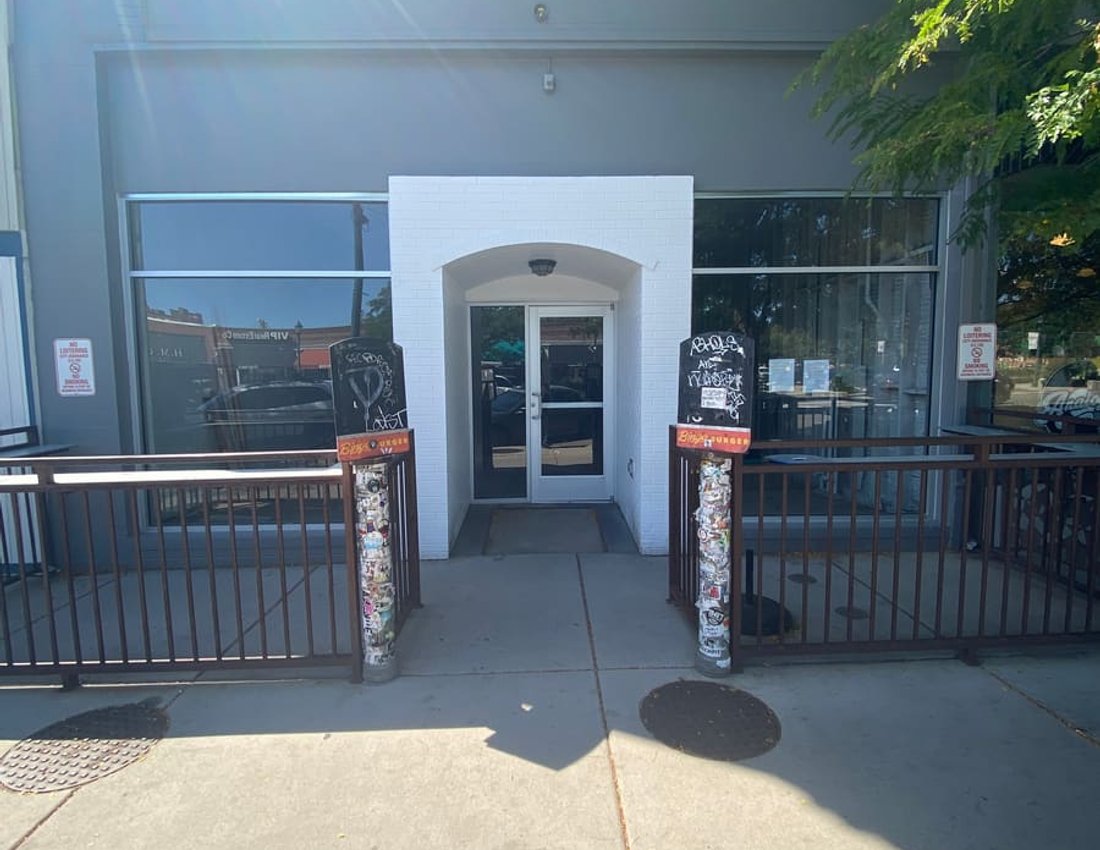 Commercial storefront entrance with glass entry door and full-height window walls installed by Kent Glass in Colorado Springs
