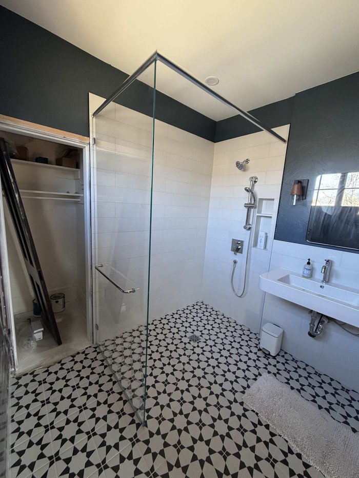 Custom frameless walk-in shower with chrome hardware and geometric tile