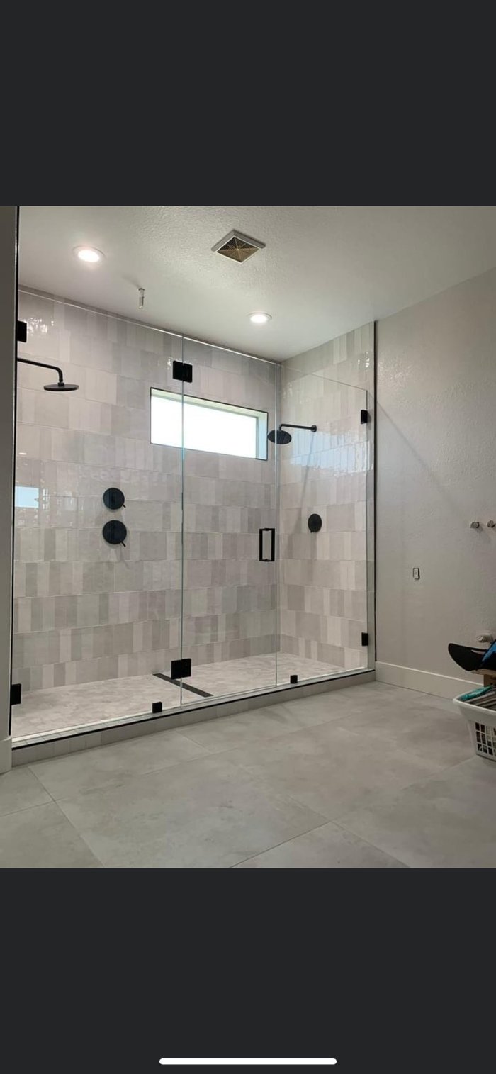 Frameless shower with glass-to-glass hinge, no header, and matte black hardware