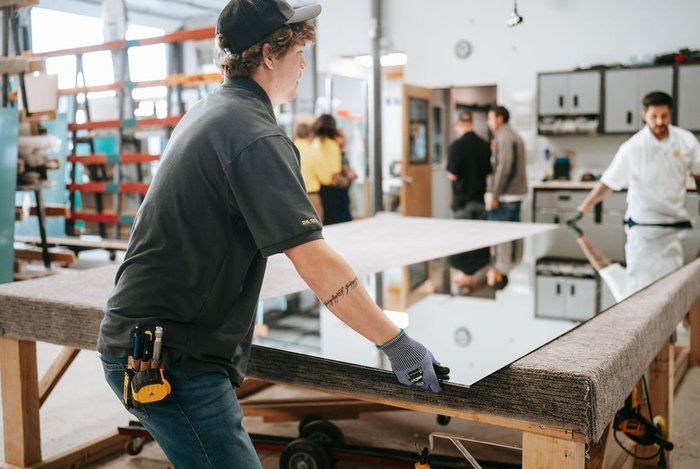 Kent Glass glazier positioning a mirror panel in the shop