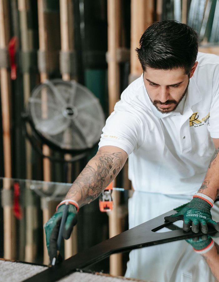 Kent Glass glazier scoring and cutting glass in the shop