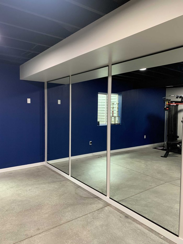 Wall-to-wall gym mirror installation in a Colorado Springs home gym
