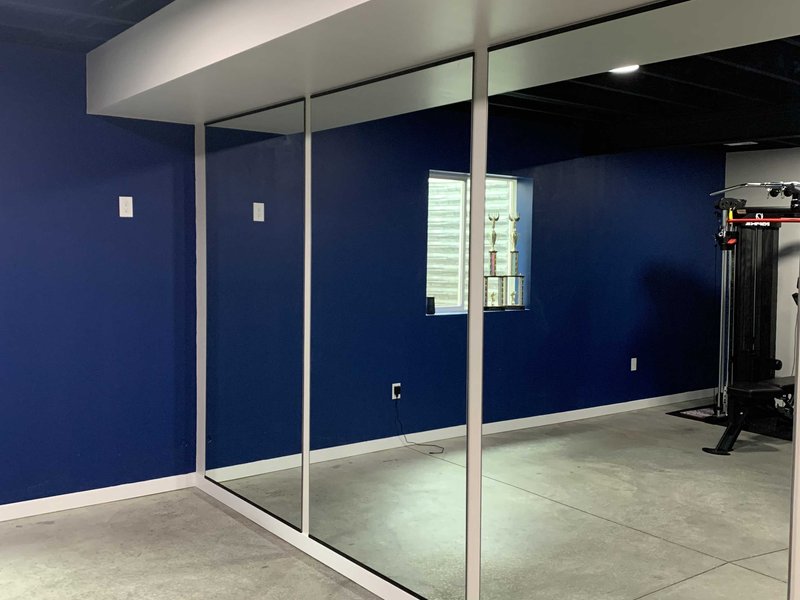 Wall-to-wall gym mirror installation in a Colorado Springs home gym